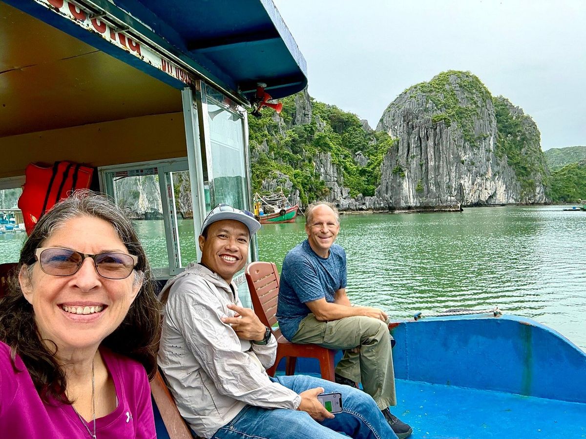 With our guide on a boat among the karst cliffs